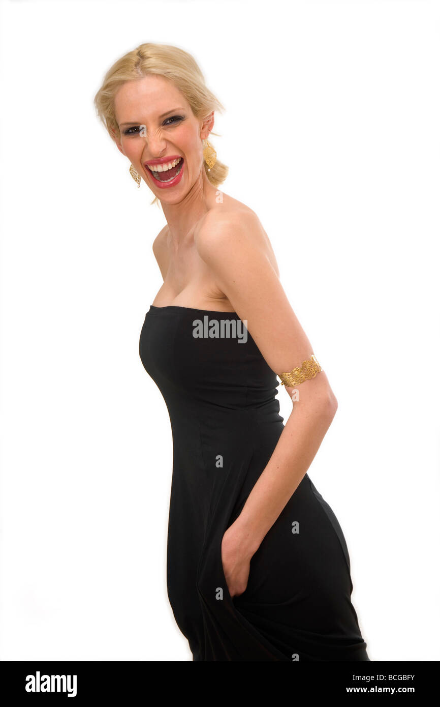 Junge weibliche blonde Modell Mitte der zwanziger Jahre mit einem schwarzen Abendkleid auf weißem Hintergrund Stockfoto