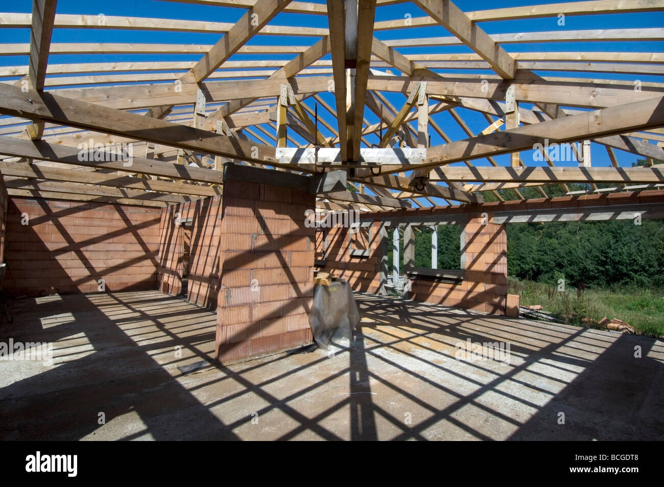 Schatten von Dachstühlen und Holzbalken Criss cross Boden und Wände eines Hauses im Bau Stockfoto