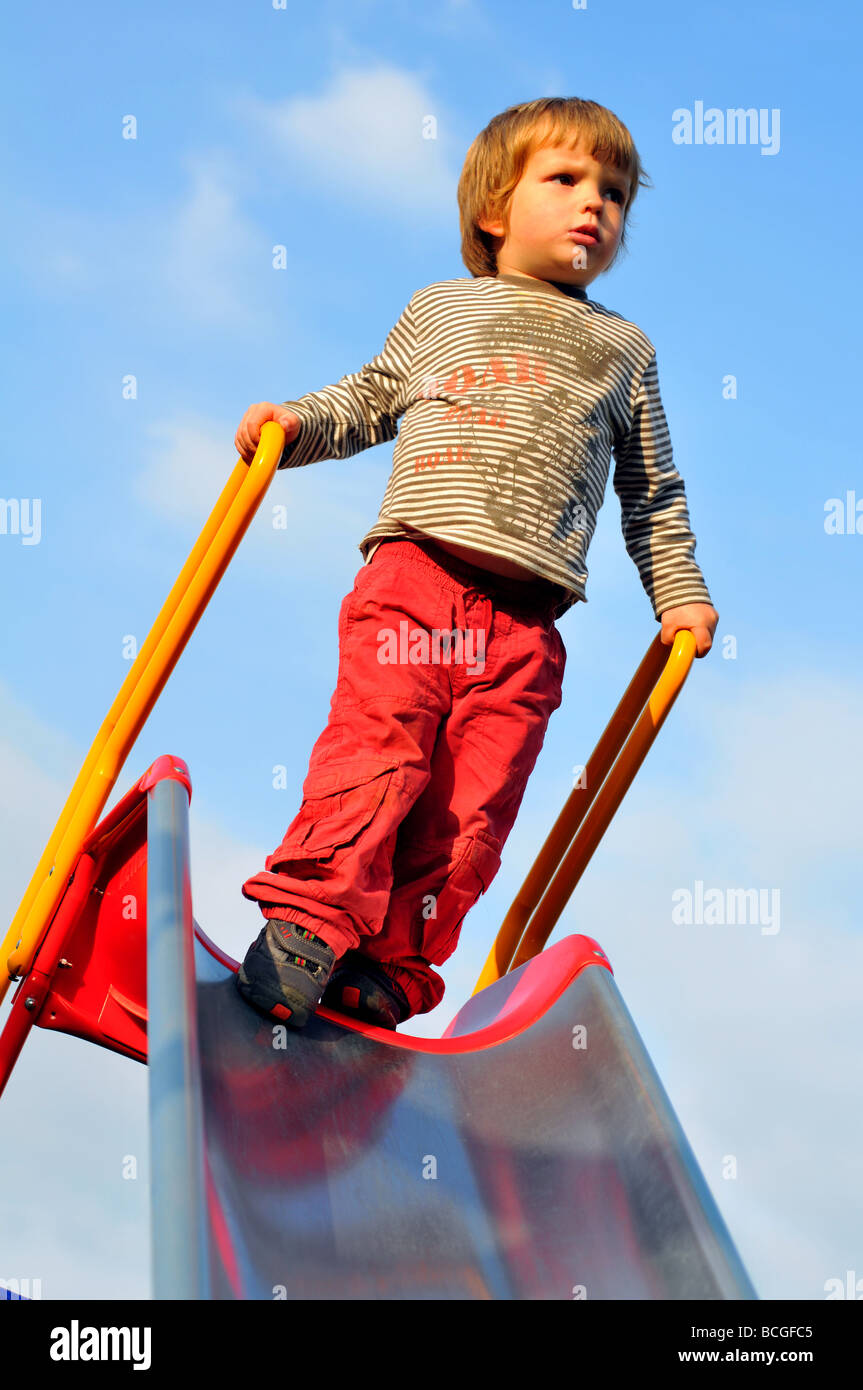 Junge spielt auf einer Folie Stockfoto