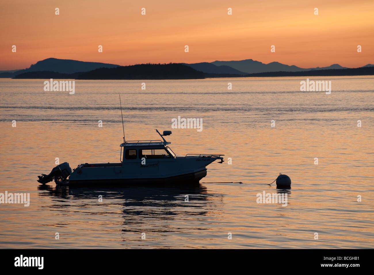 Ein Ausflugsschiff vor Anker aus Lummi Island, Washington. Im Hintergrund sind die Inseln Matia und Sucia Silhouette. Stockfoto