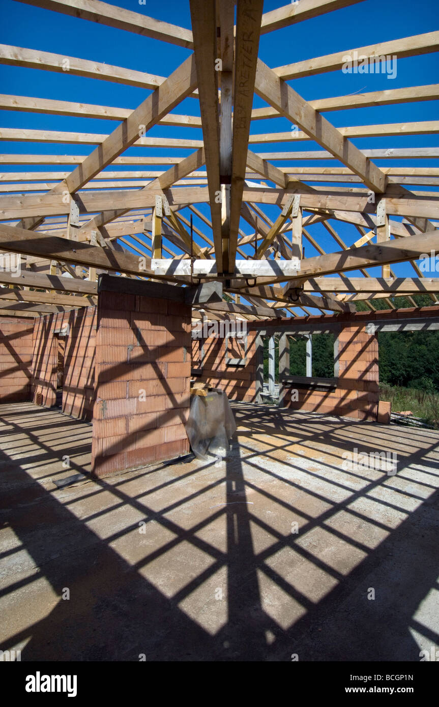 Schatten von Dachstühlen und Holzbalken Criss cross Boden und Wände eines Hauses im Bau Stockfoto
