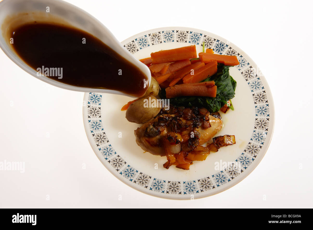 Chicken Dinner am Teller mit Soße übergossen werden Stockfoto