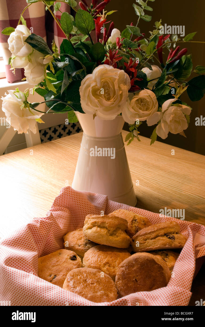 Korb mit Scones und Vase mit Blumen Stockfoto