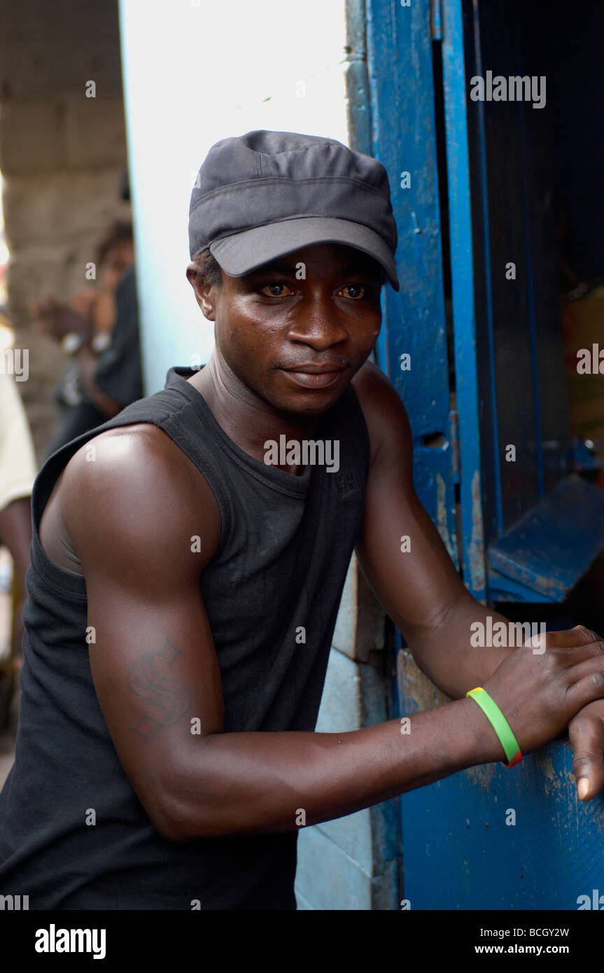 Junger Mann mit Schirmmütze, stützte sich auf Tür in Accra Ghana Afrika Stockfoto