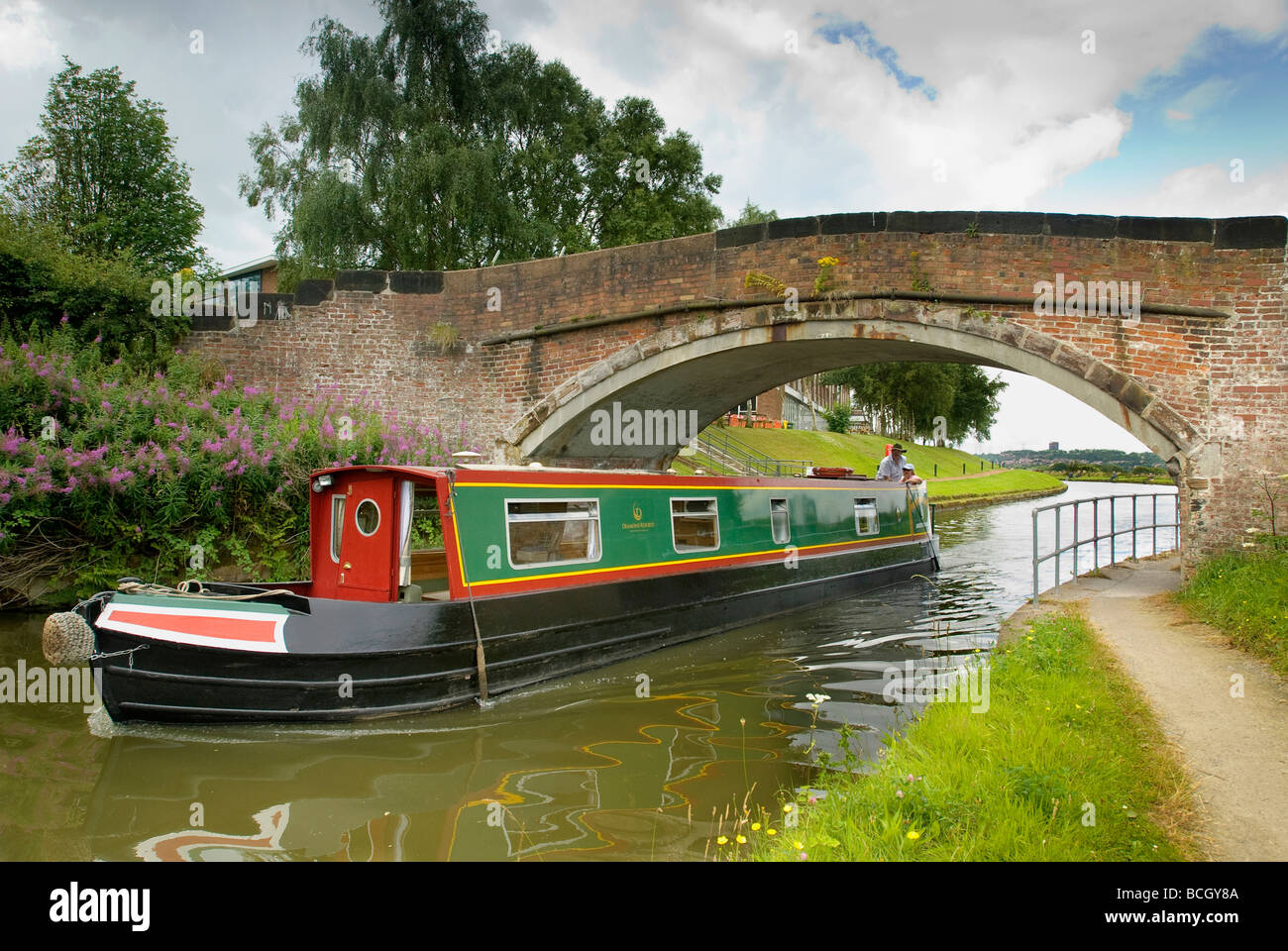Ein Narrowboat unterquert eine Brücke auf dem Bridgewater Kanal am Daresbury in Cheshire. Stockfoto