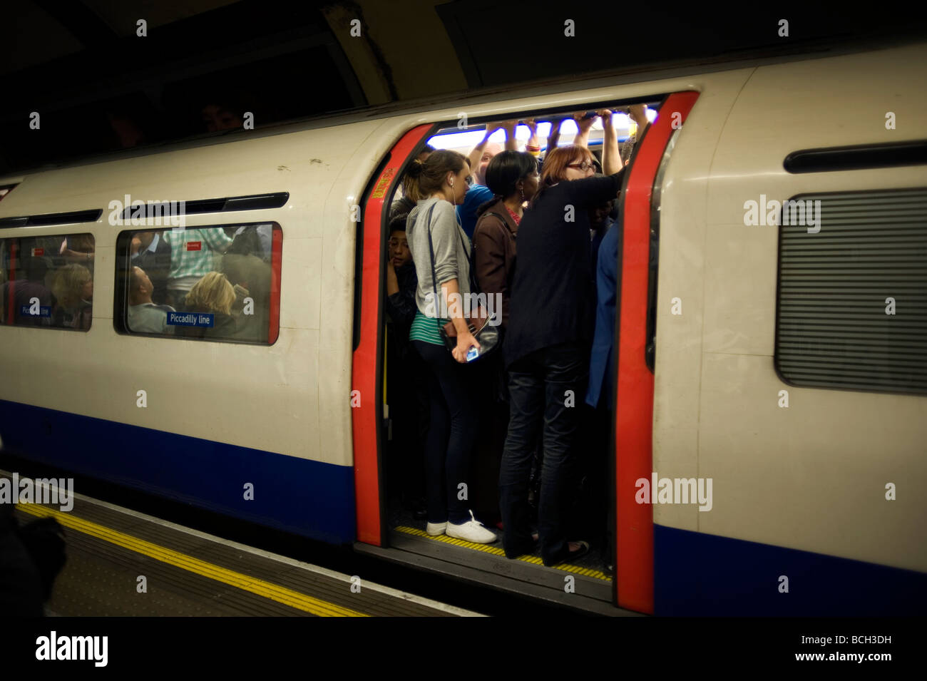 Londoner u-Bahn pendeln Crush überfüllt Reisen Piccadilly Linie heißen Schweiß straphanging Körper Geruch Touch Wärme Stockfoto