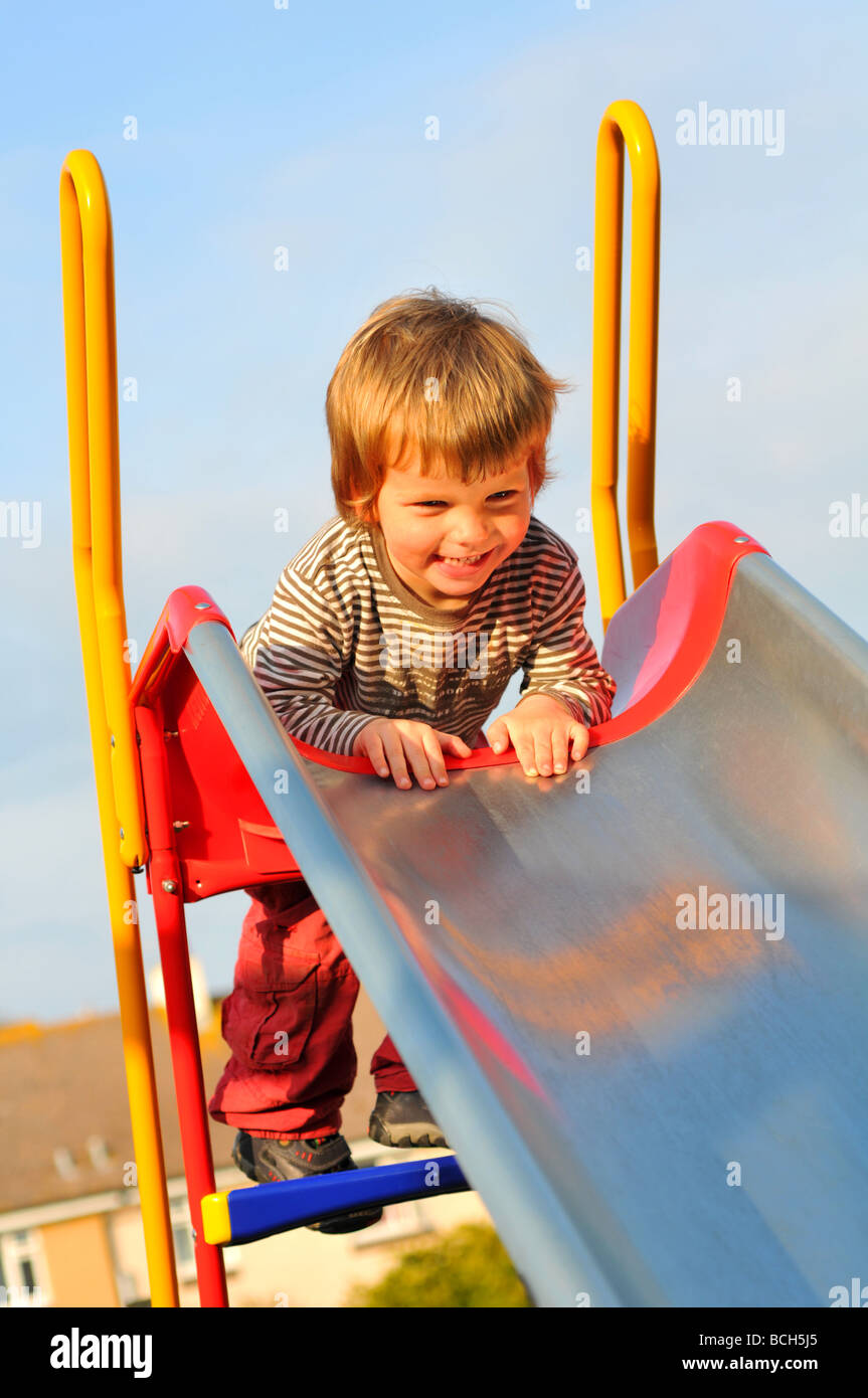 Junge spielt auf einer Folie Stockfoto