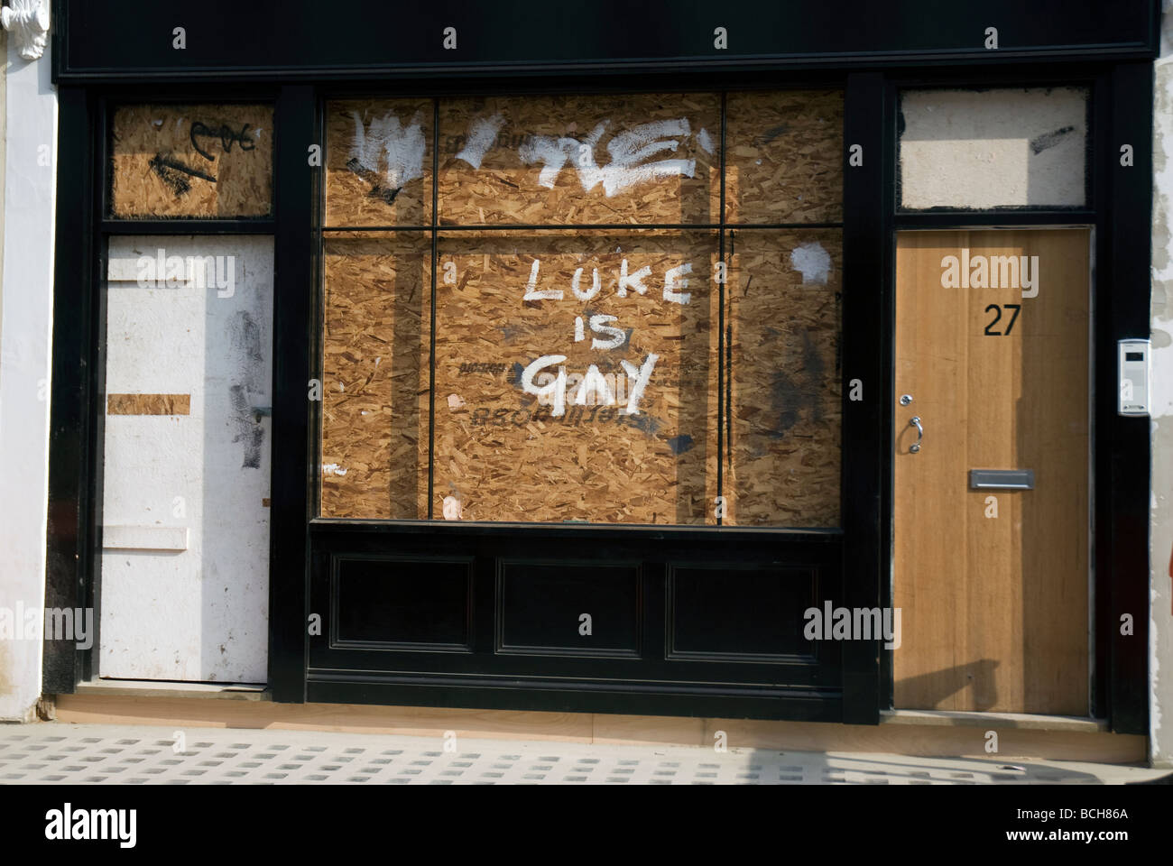Mit Brettern vernagelt Ladenfront mit offensiv homophobe grafitti Stockfoto