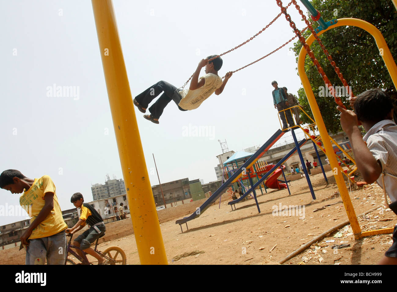 Kinder spielen auf einer Reihe von neu gebauten Schaukeln in Dharavi, der größte Bereich der Slum in Mumbai (Bombay), Indien Stockfoto