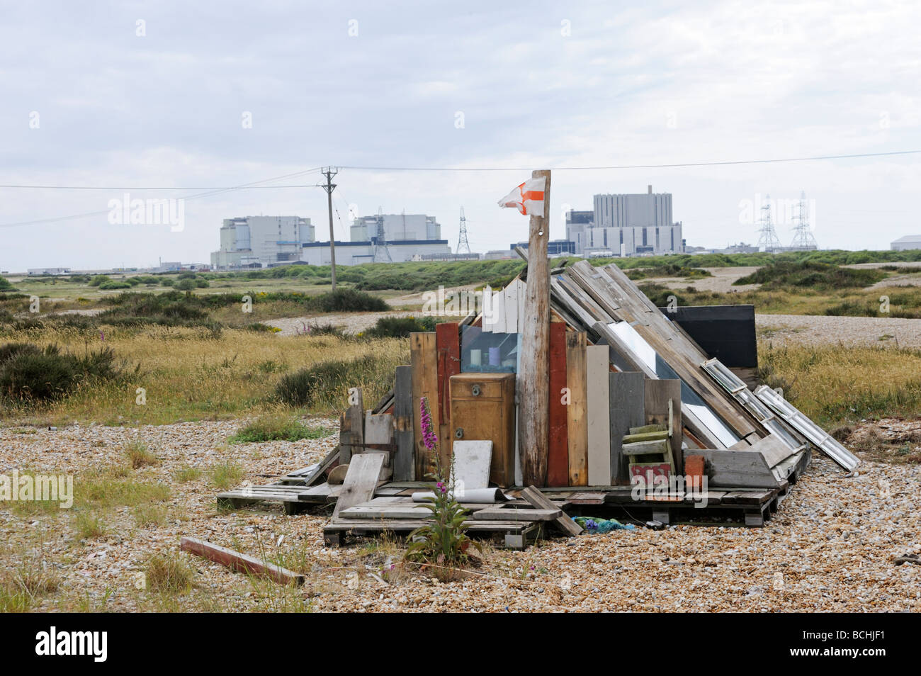 Exzentrische kleinen hölzernen unterstand, nach Hause, am Strand von Dungeness, Kernkraftwerk im Hintergrund, Kent Küste UK Stockfoto