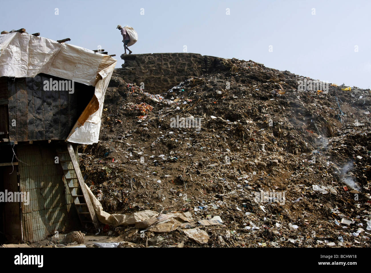 Ein Mann ist auf der Suche nach wertvollen Materialien in einer Mülldeponie in der Dharavi, Slum in Mumbai (Bombay) sind, in Indien. Stockfoto