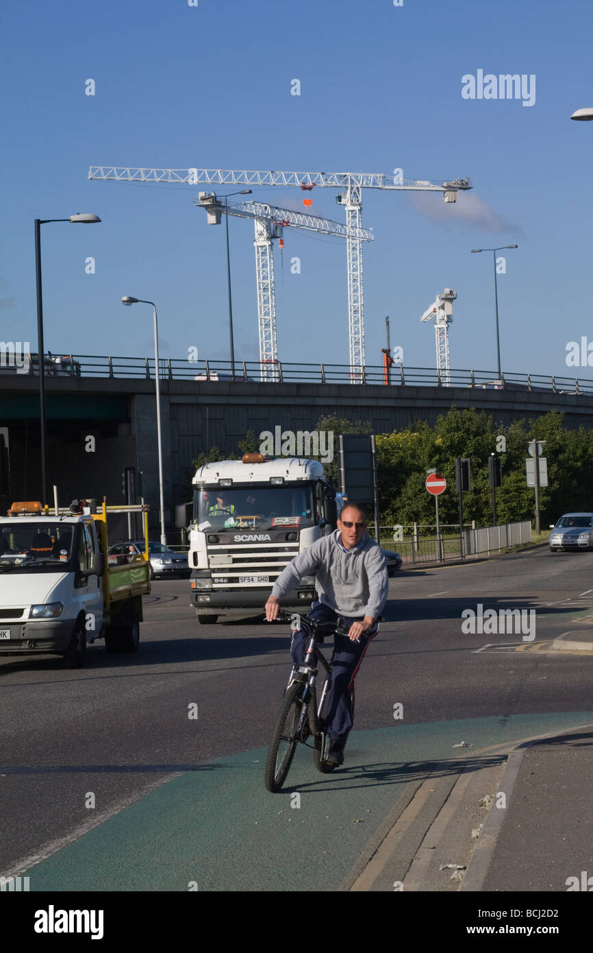 Ein Radfahrer mit Kräne im Hintergrund. London. VEREINIGTES KÖNIGREICH. Stockfoto