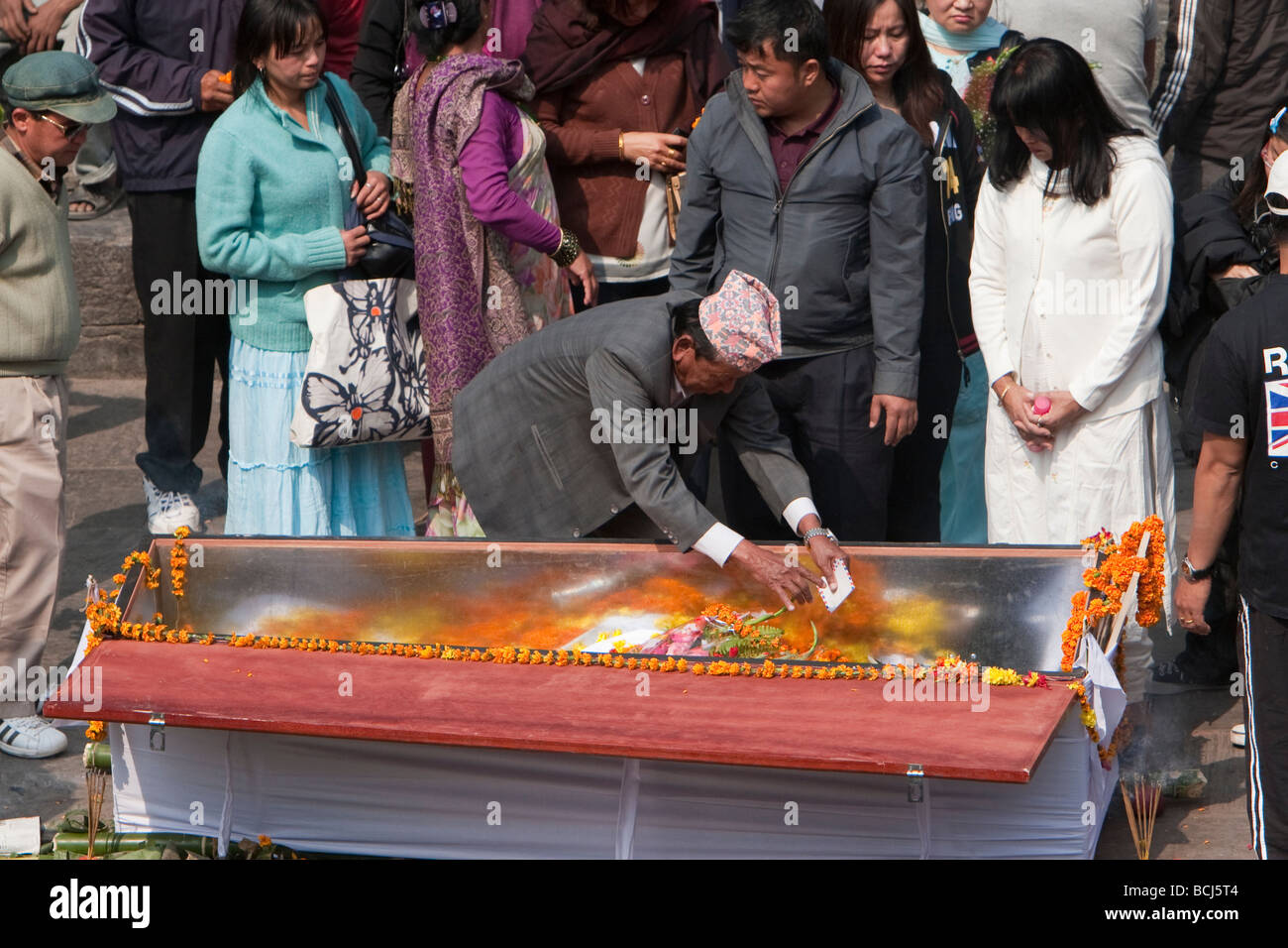 Pashupatinath, Kathmandu, Nepal. Familienmitglied legt Blumen und einen Brief in einem Sarg eines Verstorbenen. Stockfoto