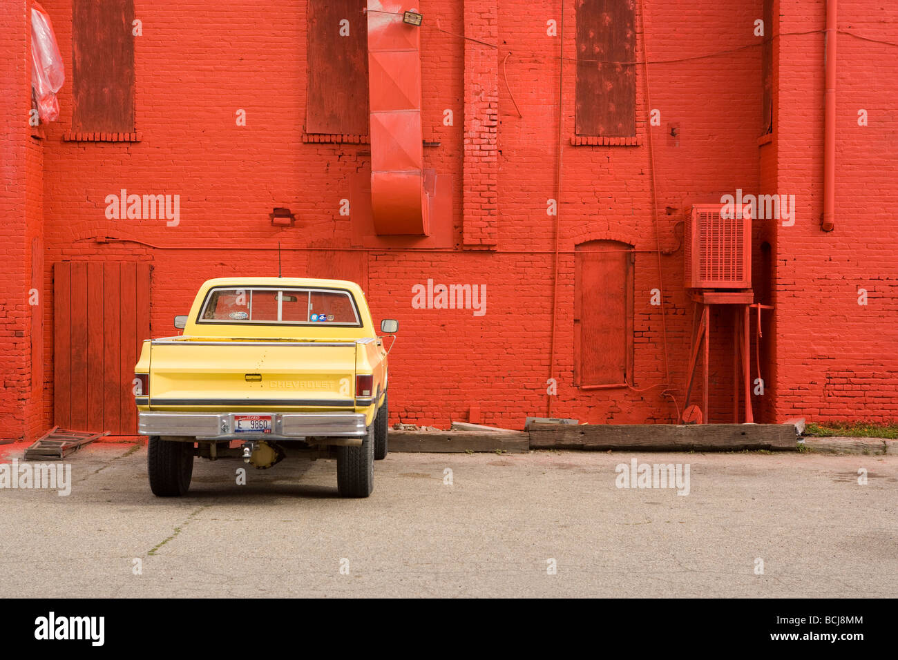 Gelbe Pickup-Truck parkte vor roten Backsteinmauer Stockfoto