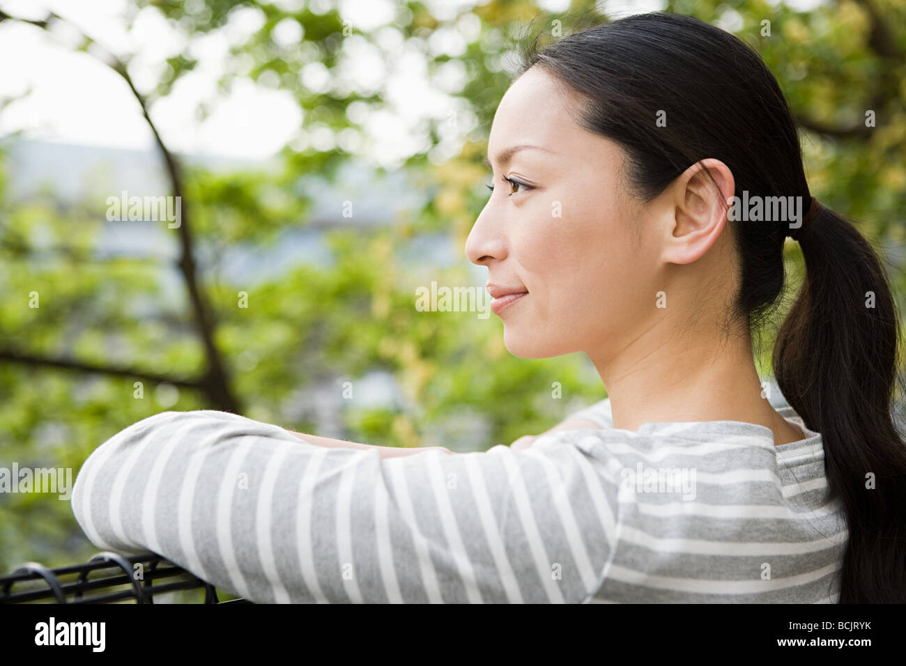 Japanische Frau lehnt sich in der Nähe von Bäumen Stockfoto