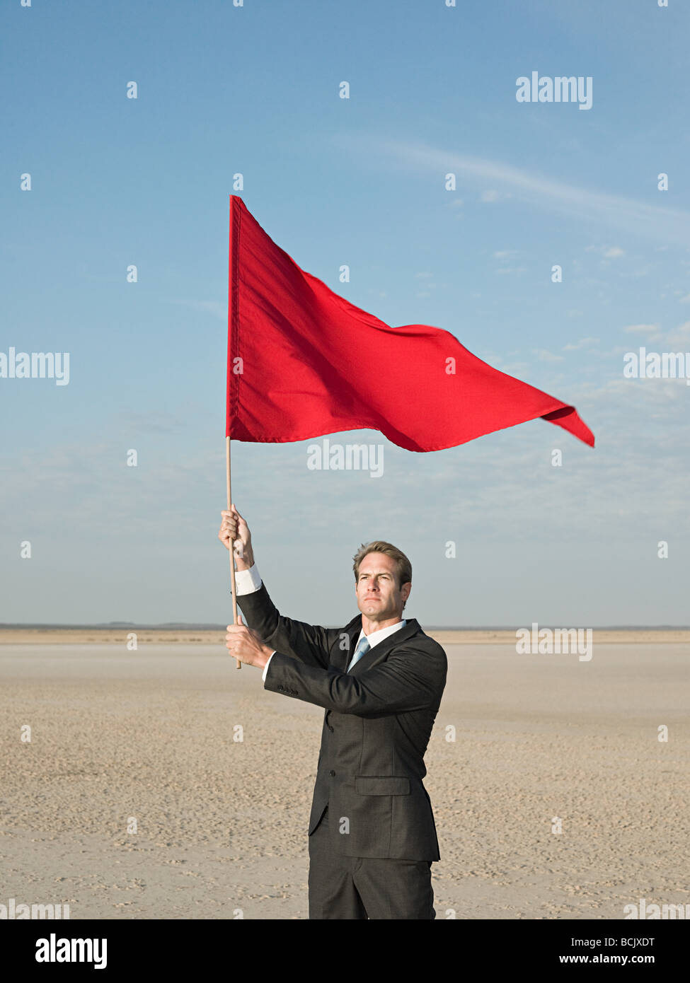 Geschäftsmann hält eine rote Fahne Stockfoto