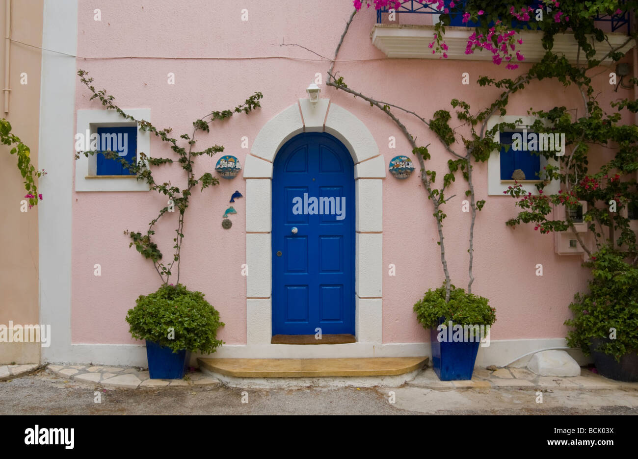 Ferienhäuser und Ferienwohnungen mit Trauerweiden im Dorf Assos auf der griechischen Insel Kefalonia Griechenland GR bedeckt Stockfoto