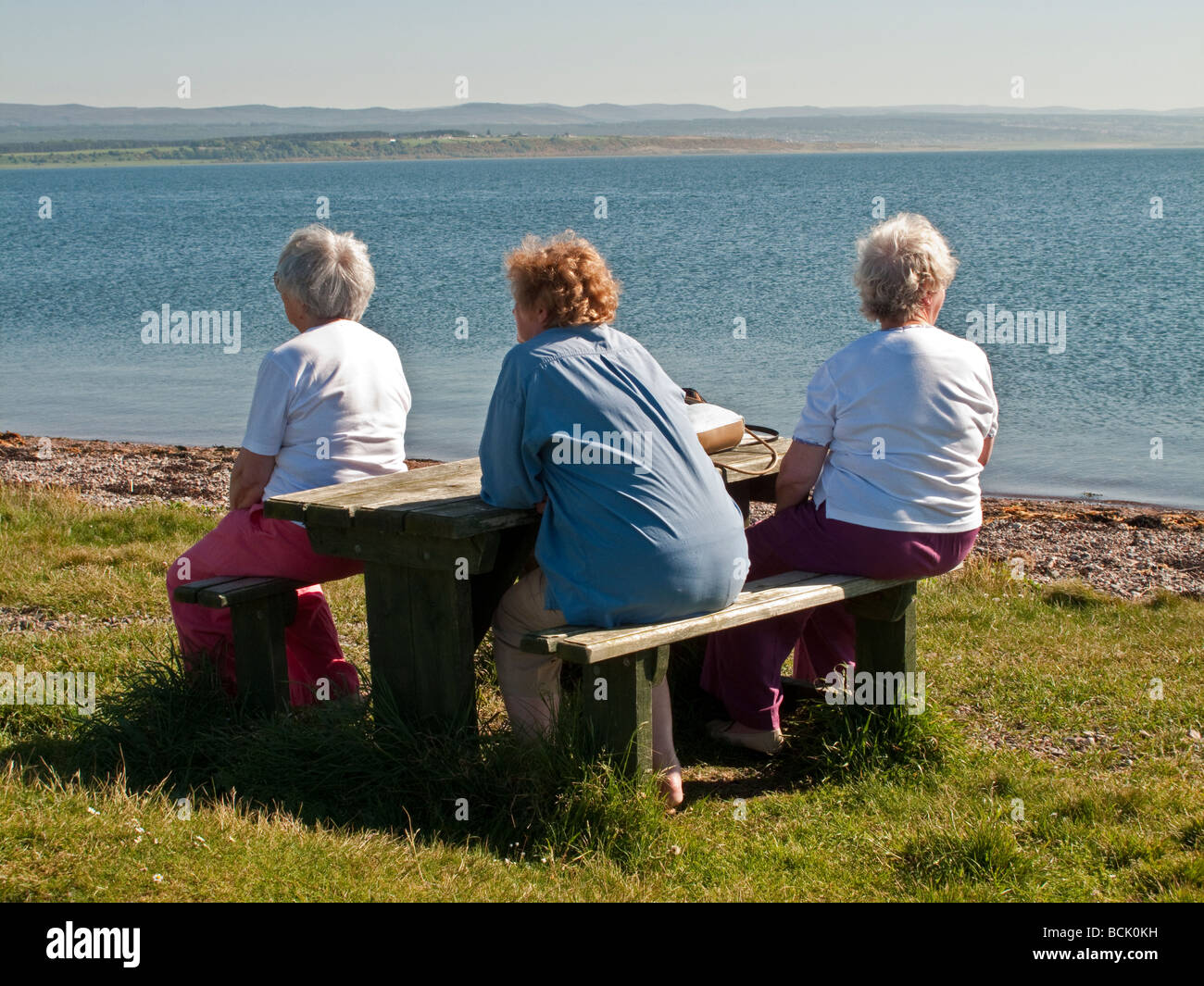 Drei Elderley Damen Ausschau nach Delfinen am Chanonry Point in Schottland, Vereinigtes Königreich Stockfoto