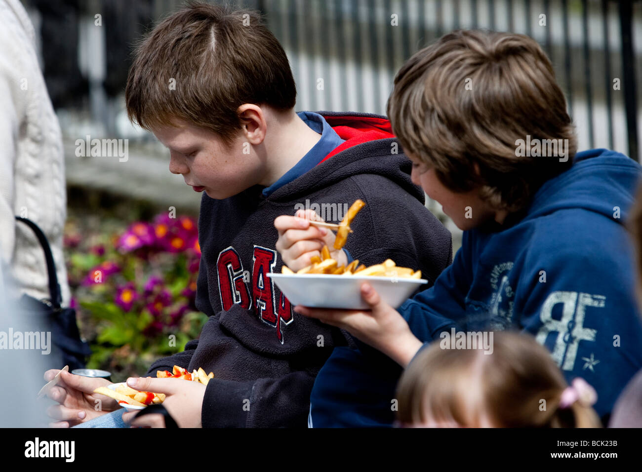 Touristen Essen Fisch und Chips auf Bowness Bay front Stockfoto