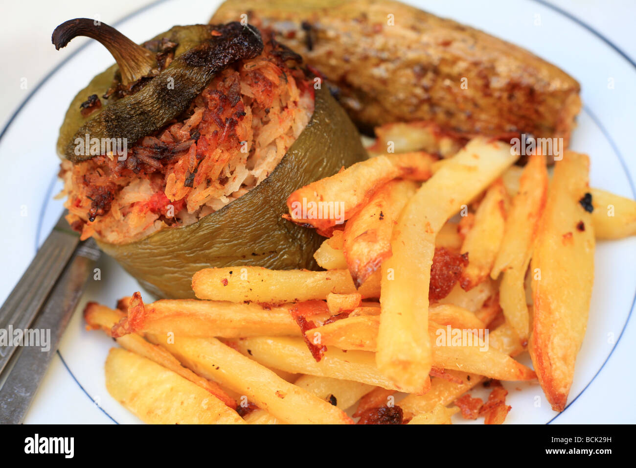 Gefülltes Gemüse im griechischen Stil mit Fleisch und Reis gefüllt mit Ofen gebratene Kartoffelchips oder Pommes frites serviert Stockfoto