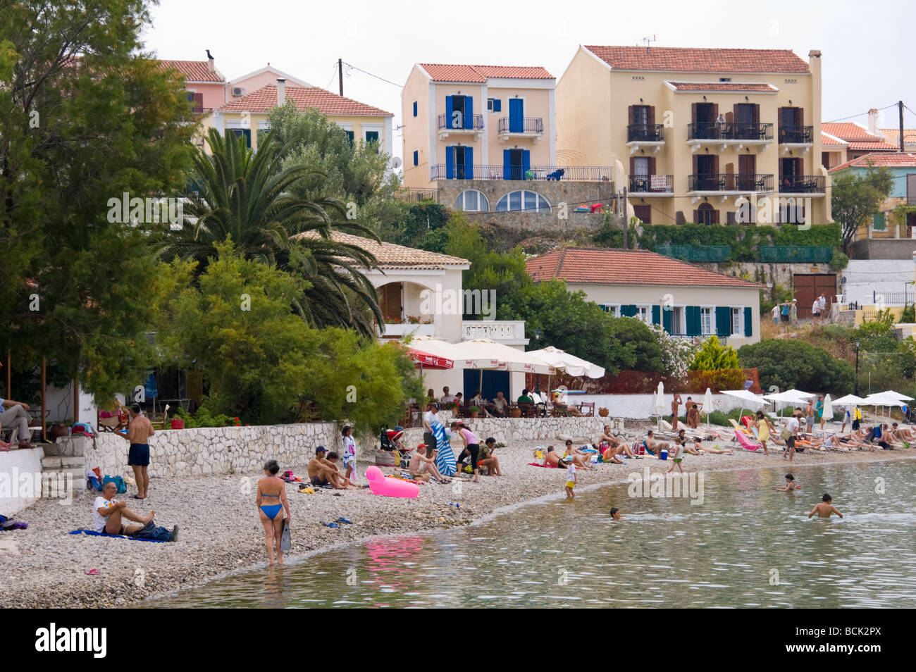 Blick über den Strand und den Hafen mit Blick auf Ferienhäuser und Ferienwohnungen bei Assos auf griechischen Insel von Kefalonia Griechenland GR Stockfoto