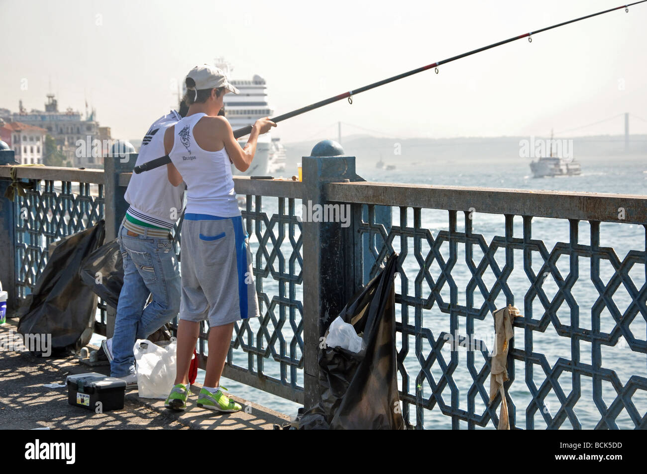 Angeln von der Galata-Brücke in den Bosporus in Istanbul, Türkei Stockfoto