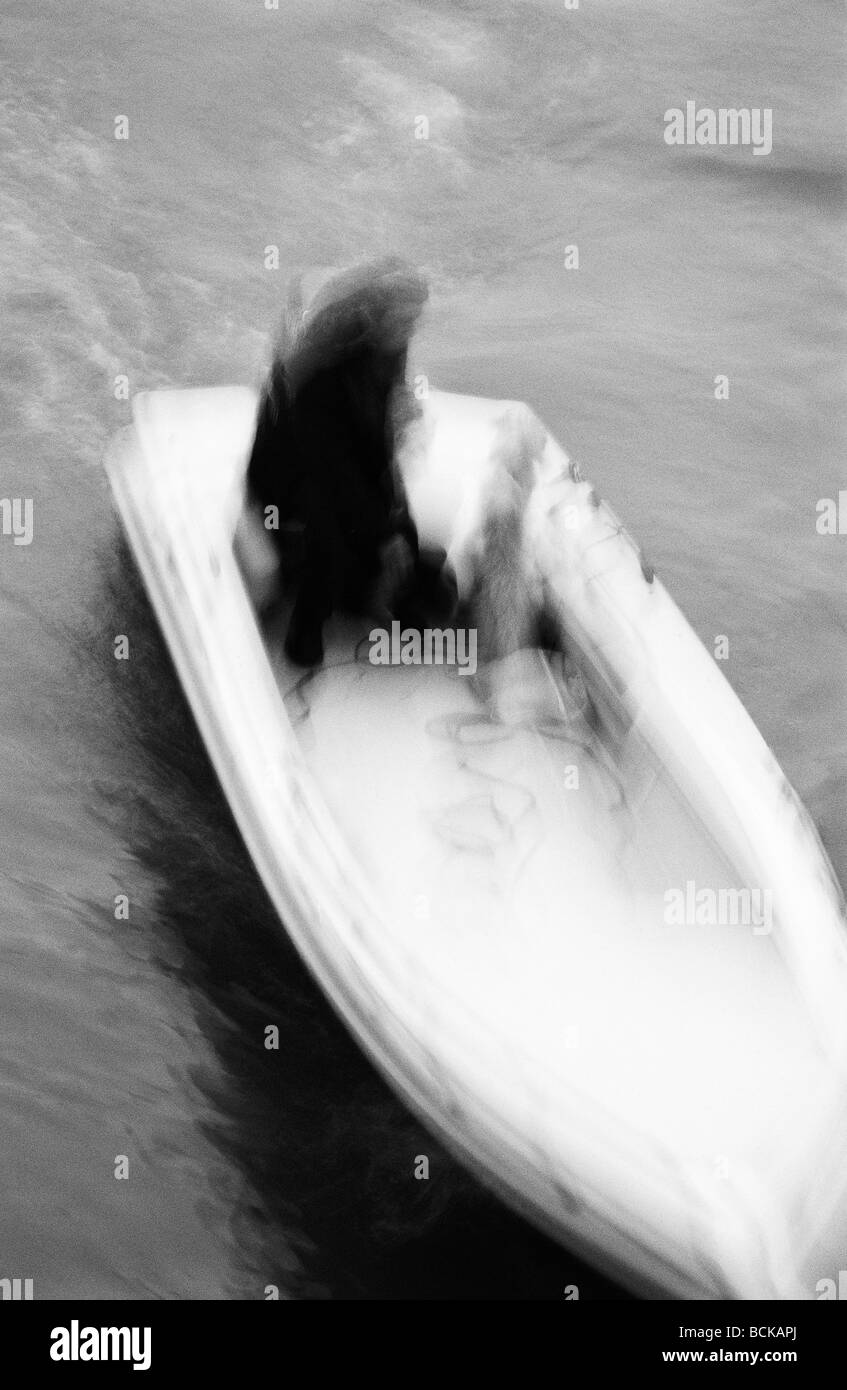 Person im Motorboot, verschwommen, erhöhte Ansicht, b&w Stockfoto