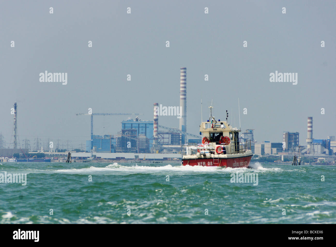 Venedig - Ansicht der Chemie- und ölverarbeitenden Industriegebiet in der Nähe von Mestre mit einem Feuer Tenderboot im Vordergrund Stockfoto