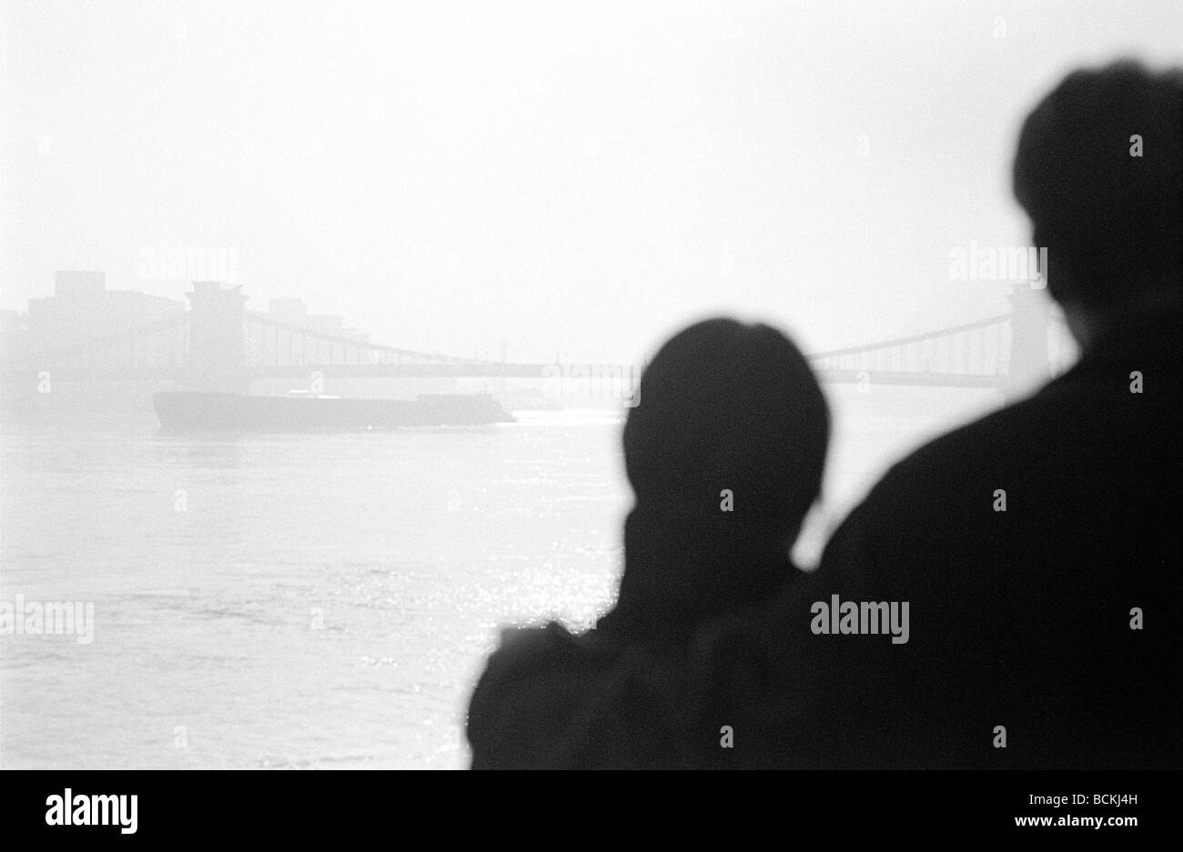 Paar steht vor Flusslandschaft mit Brücke, Rückansicht Stockfoto