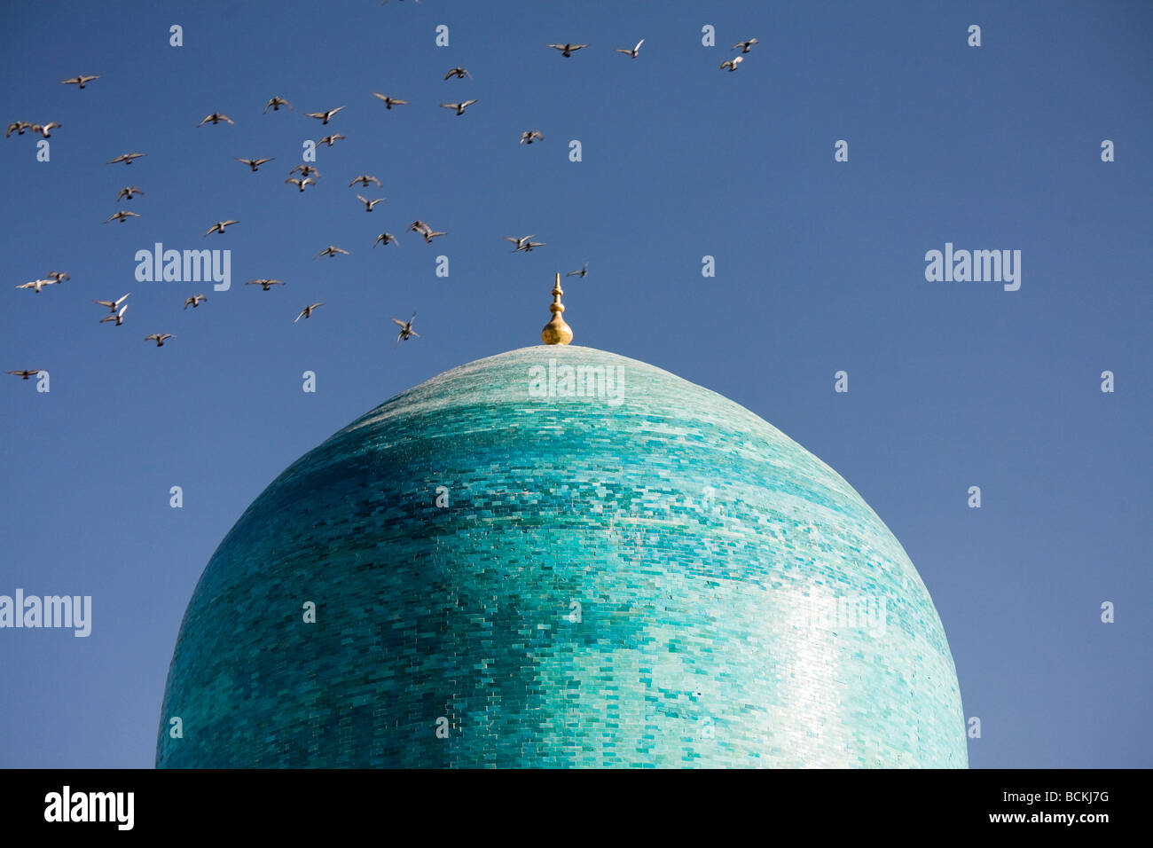 Vogelschwarm fliegt über der Kuppel der Moschee Stockfoto