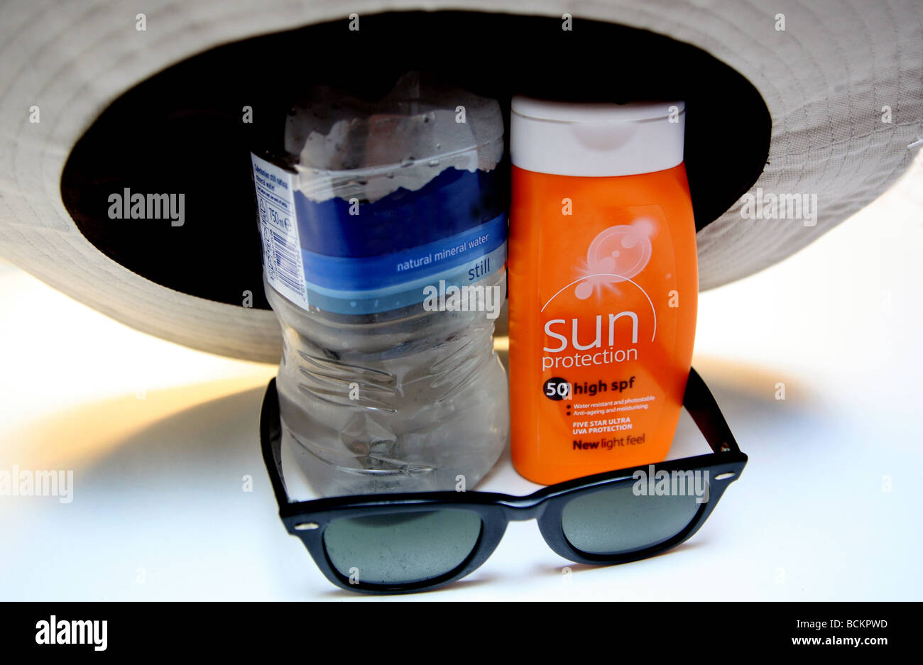 Heißem Wetter Vorsichtsmaßnahmen - Wasser, Sonnencreme, Sonnenbrille Stockfoto