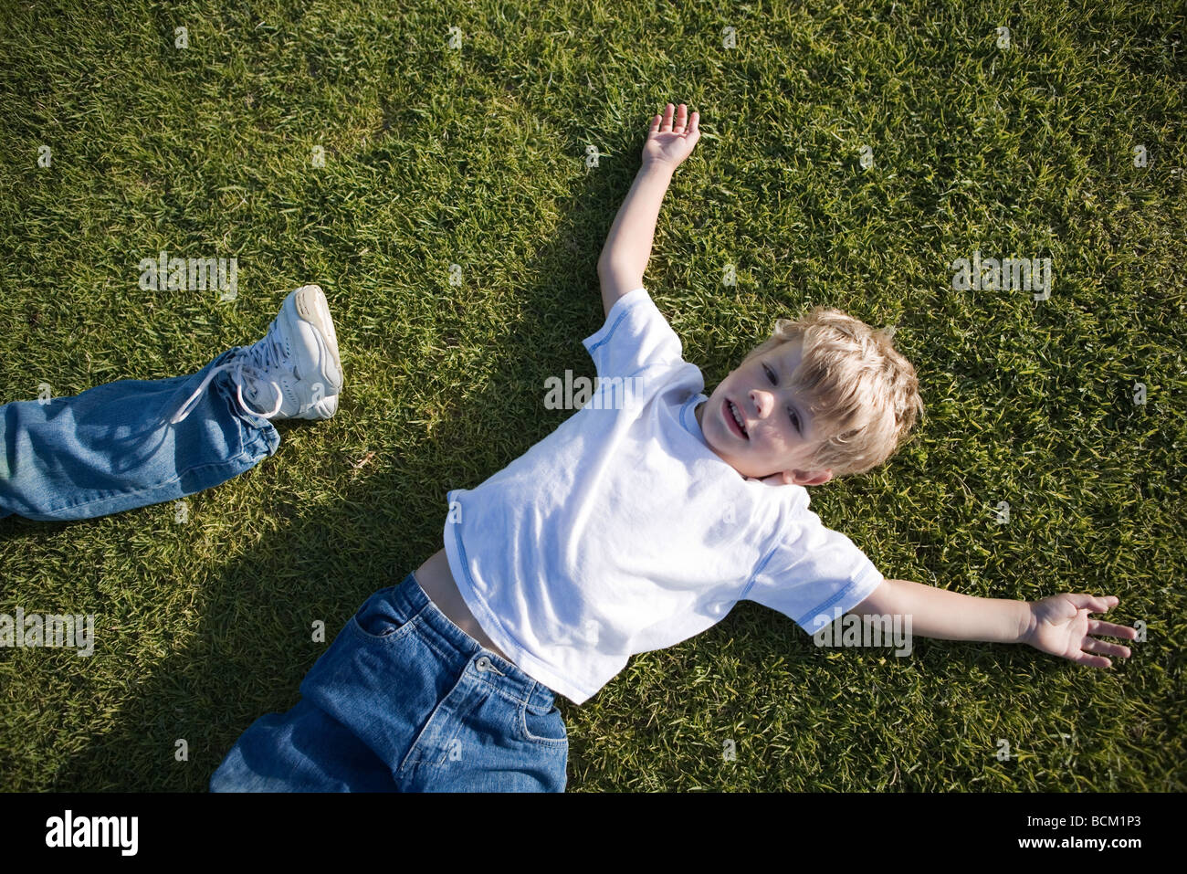 Junge auf dem Rasen, erhöhte Ansicht liegend Stockfotografie Alamy