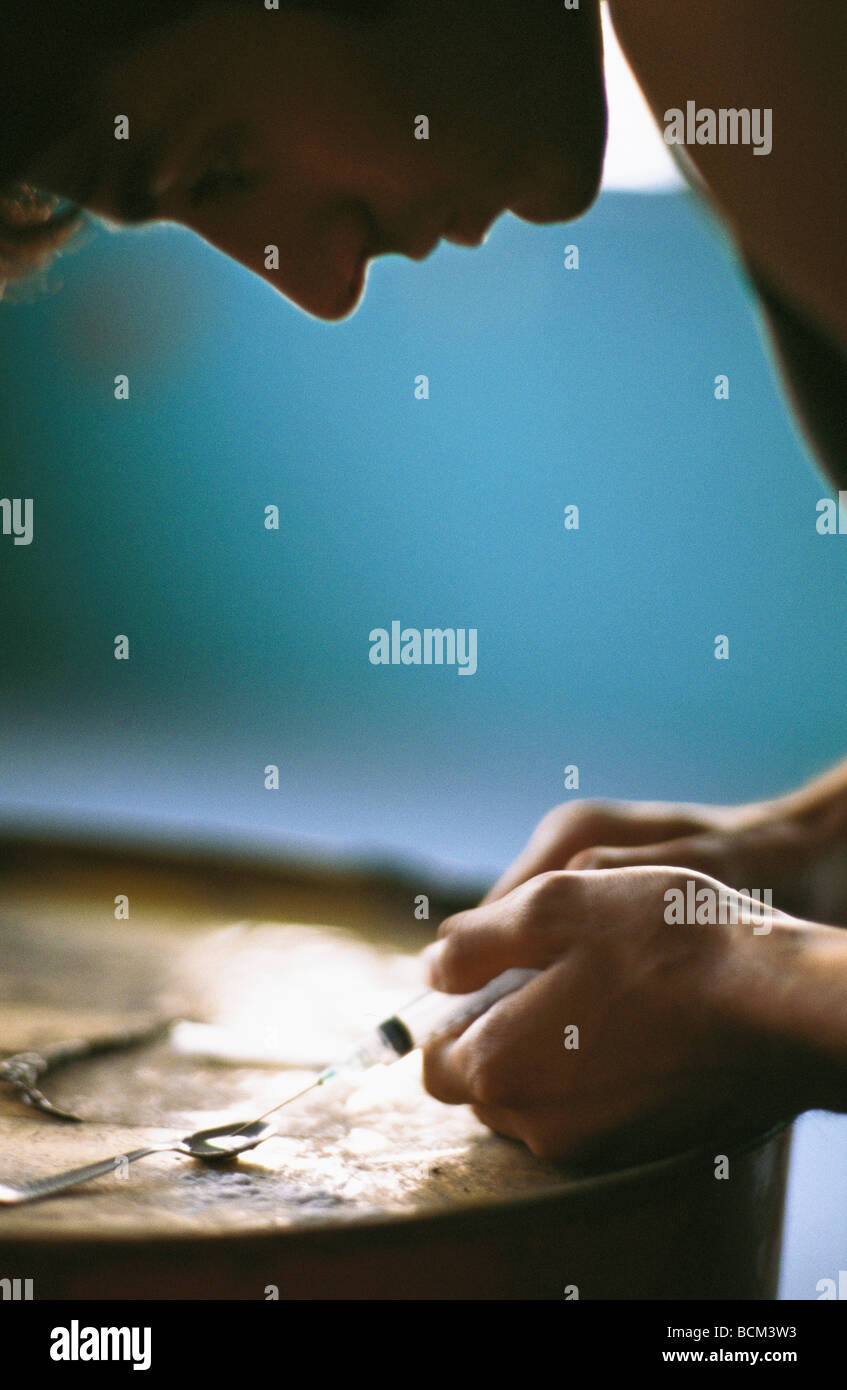 Mann, illegale Droge mit Löffel und Spritze nehmen Vorbereitung Stockfoto