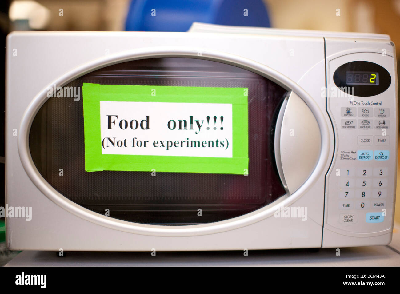 Mikrowelle mit Schild mit der Aufschrift Lebensmittel nicht nur für Experimente im Labor Stockfoto