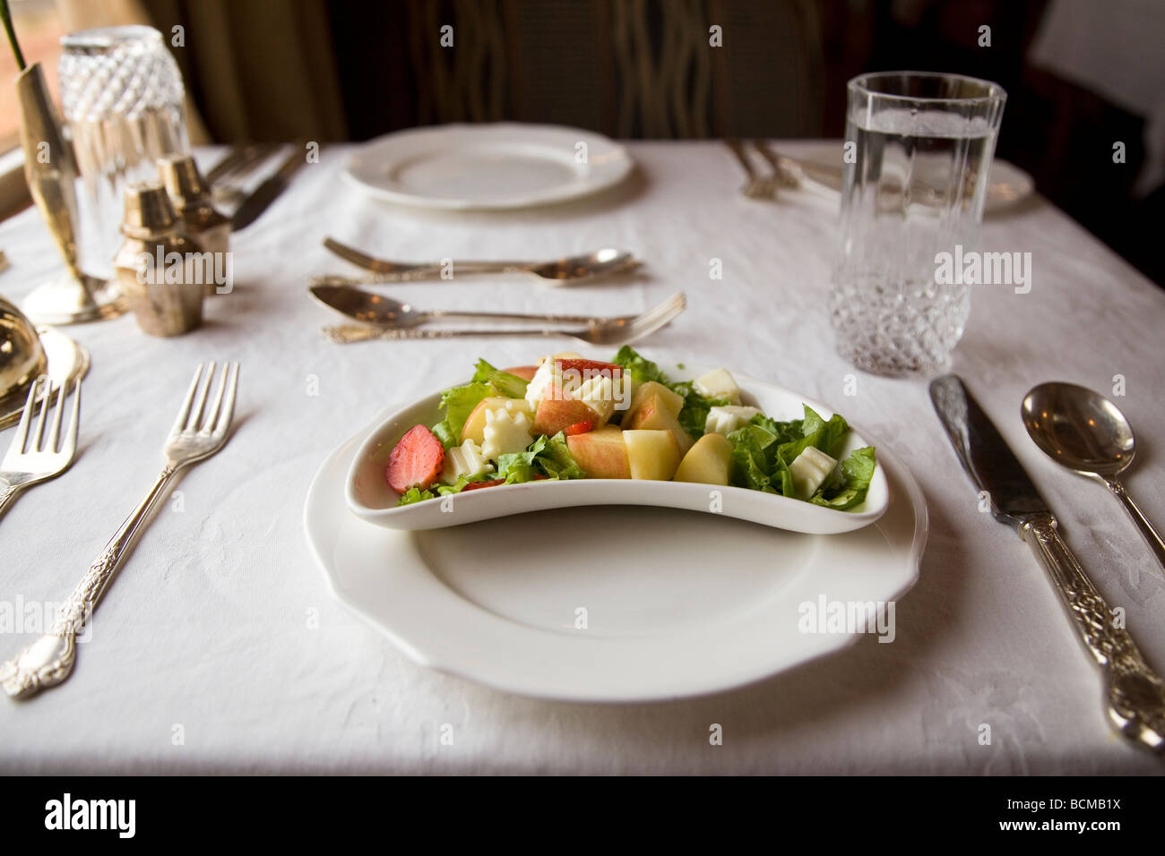 Eine Tabelle wird für ein Dinner im kontinentalen / western Stil festgelegt. Besteck für mehrere Kurse wird eingestellt und ist betriebsbereit. Stockfoto