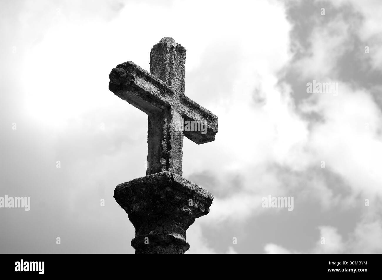 Ein Stein gemeißelt Kruzifix vor einem bewölkten Himmelshintergrund. Stockfoto