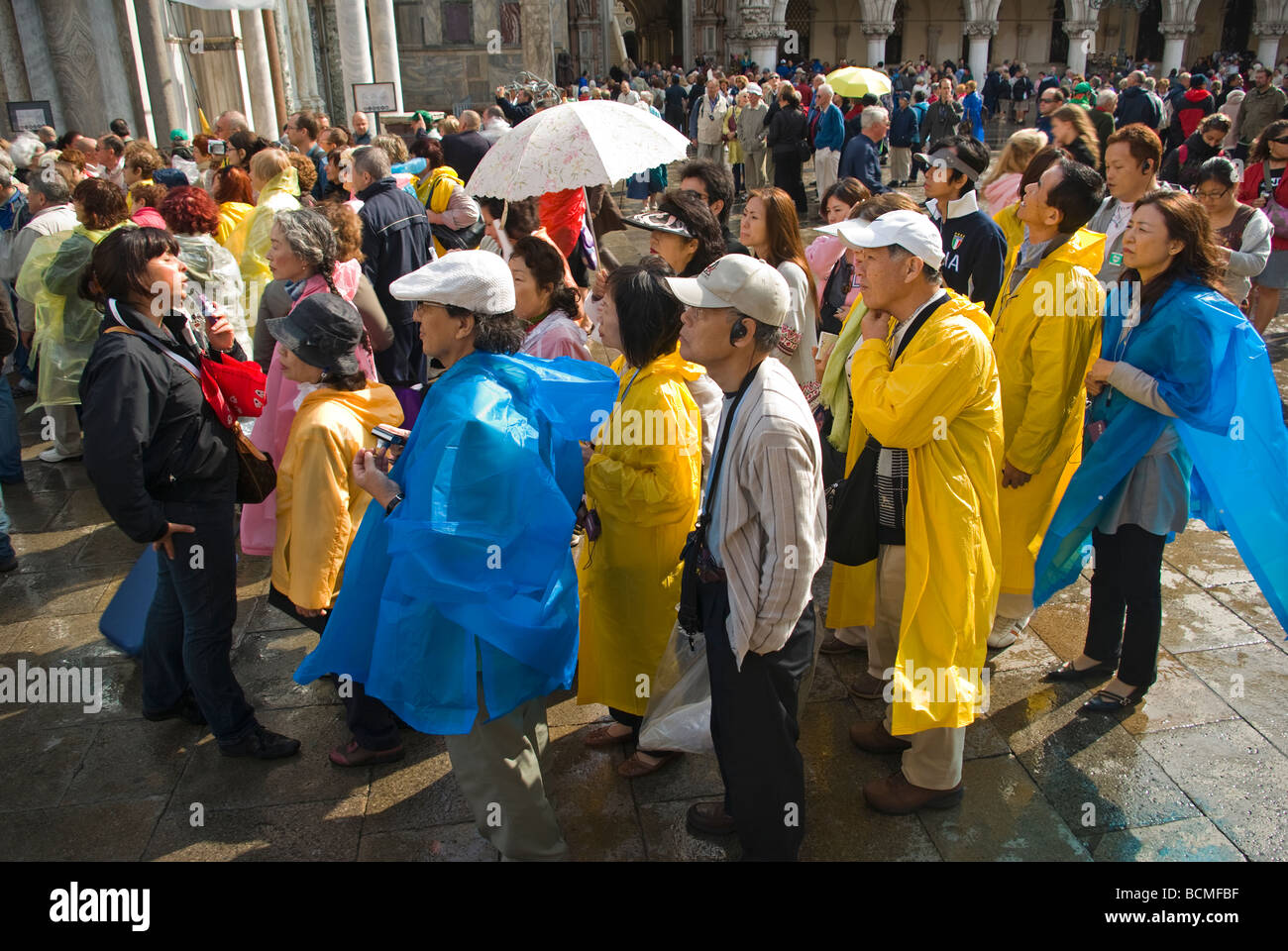 Italien Venetien Venedig Venezia Piazza San Marco St Mark s Quadrat bestimmt Reisende hören bei San Marco als Regen Abaits führen Stockfoto