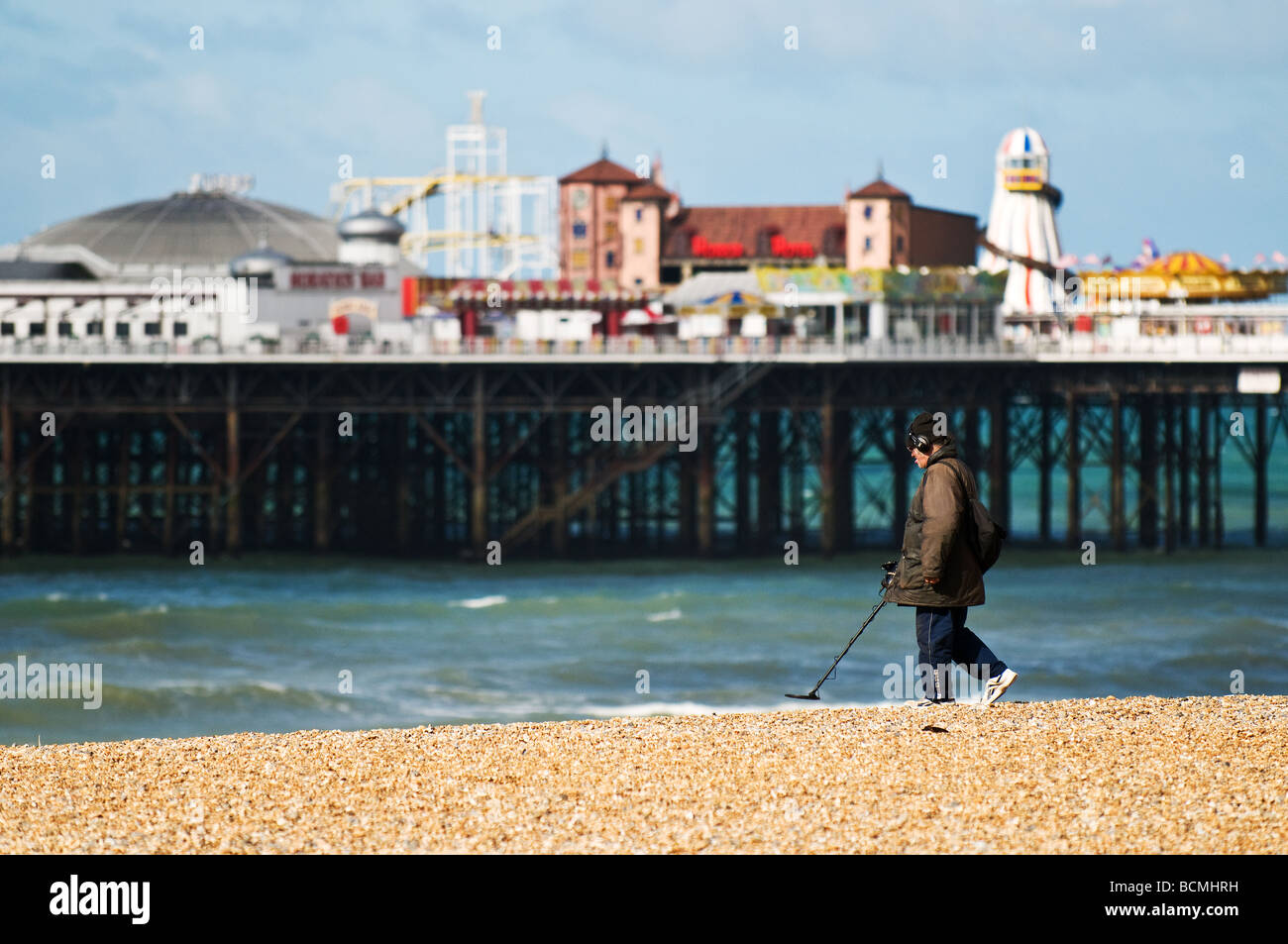 Ein Metalldetektor auf der Suche am Kiesstrand nahe Brighton Pier in Sussex. Stockfoto