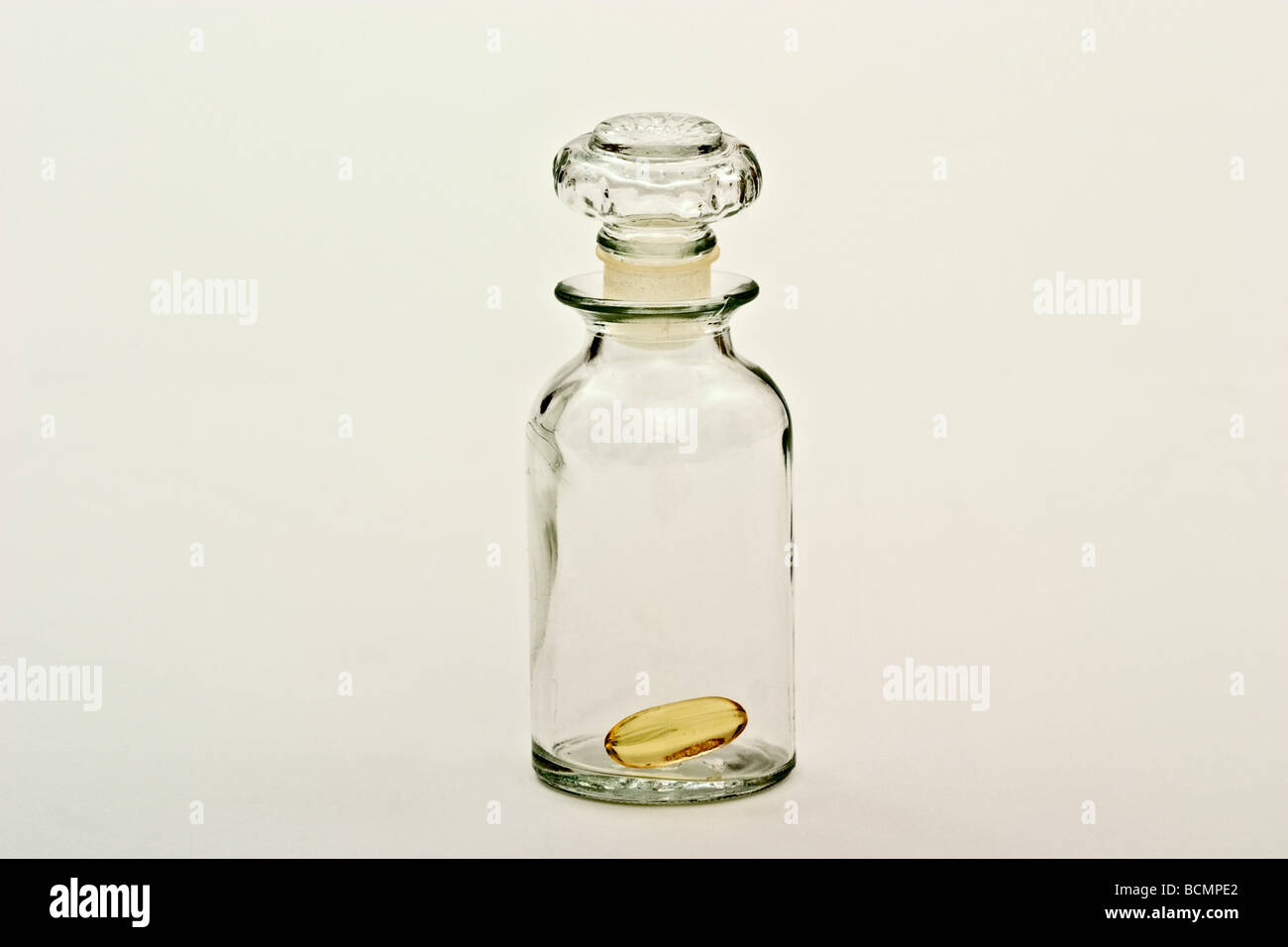 Einzelnen Vitamin-Pille in eine alte altmodische Apotheker-Flasche. Stockfoto