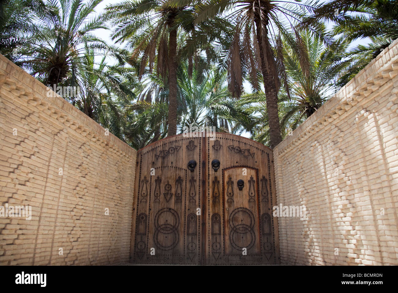 Der Eingang zu einer Verbindung in der Oase Tozeur zeigt eine traditionelle tunesische Holztür und der Stadt einzigartige Mauerwerk Stil Stockfoto