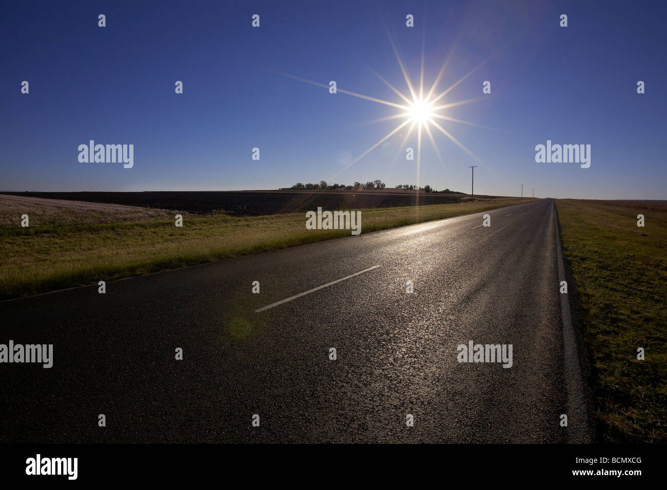 Sonne über leere Landstraße Stockfoto