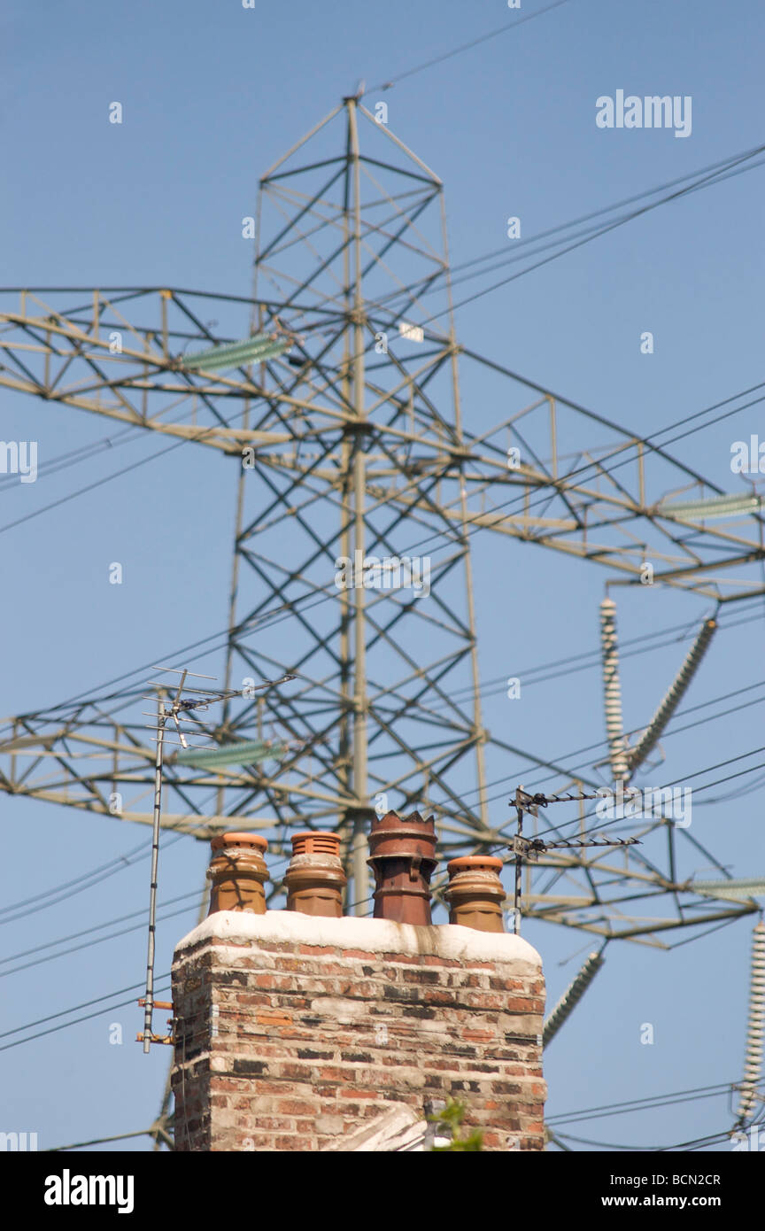 Strom-Pylon und Haus-Schornstein Stockfoto