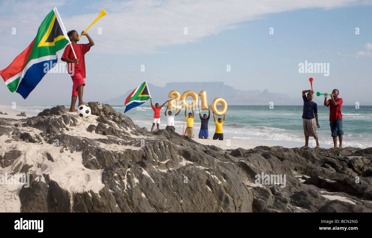 Gruppe von jungen am Strand weht Vuvuzelas und goldenen Ballons Zahlen für das Jahr 2010, Blouberg Strand Wattierung halten Stockfoto