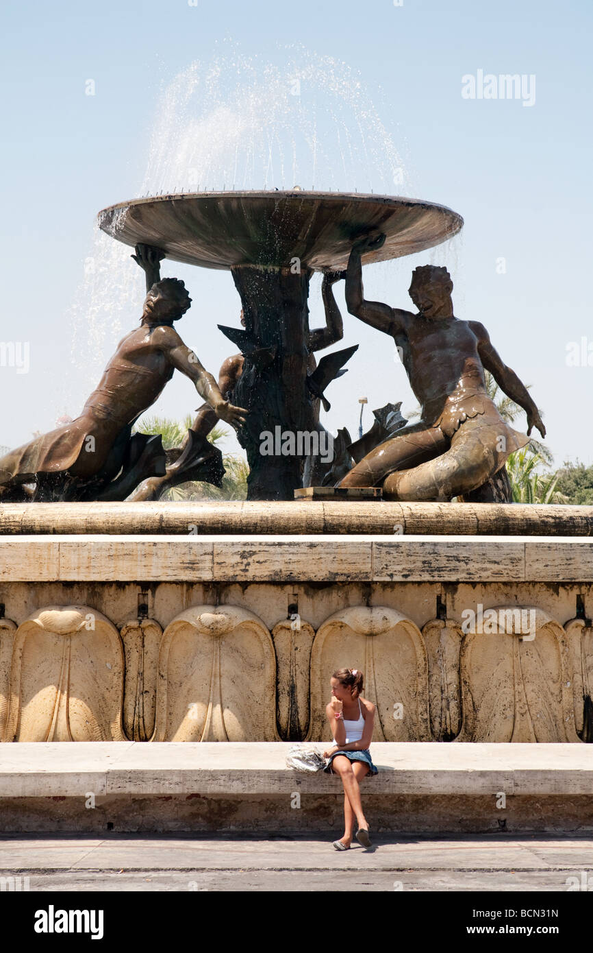 Eine Mädchen sitzt der Triton-Brunnen vor dem Tor nach Valletta, Malta Stockfoto