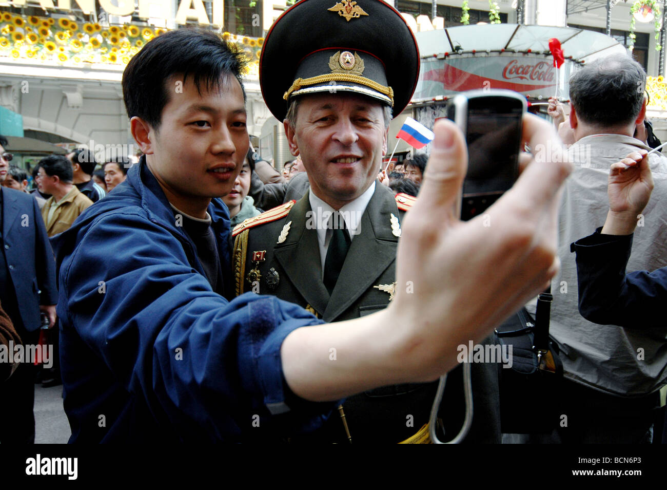 Junge Chinesen Mann nehmen Foto mit russischer Marineoffizier in Uniform mit Handy, Shanghai, China Stockfoto