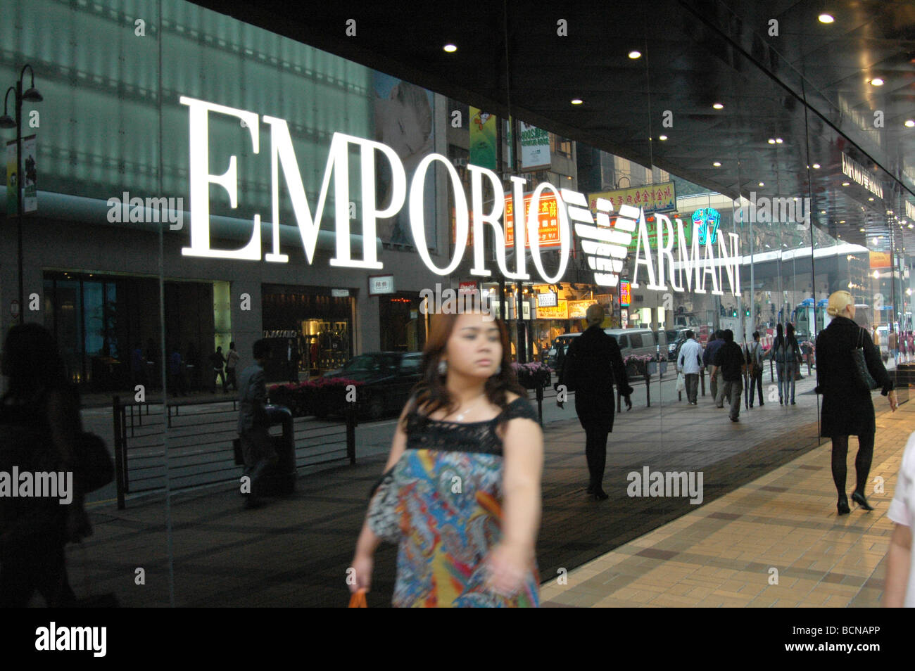 Junge Chinesin Spaziergang passieren Flagship Store von Emporio Armani, Shanghai, China Stockfoto