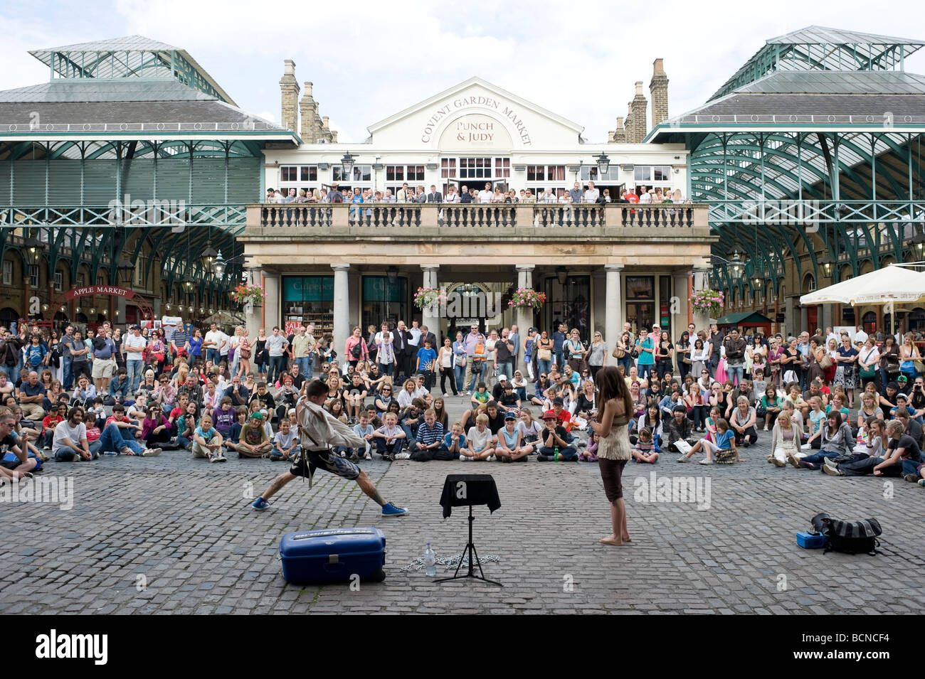 Eine Straße Entertainer führt zu einer großen Schar von Touristen in Covent Garden in London. Stockfoto