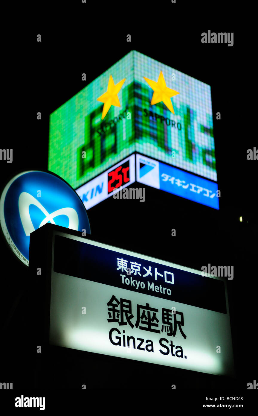 U-Bahn-Schild mit Werbung Bildschirme im Hintergrund im Ginza-Viertel Tokio Japan Stockfoto