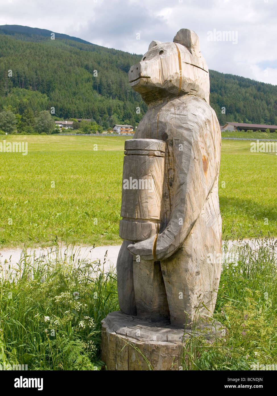 A grob geschnitzt aus Holz Bär über Fußweg im österreichischen Tirol Stockfoto