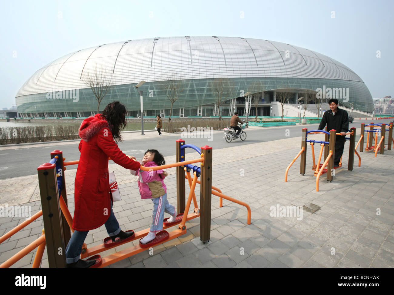 Mutter und Kind spielt auf das Sportgerät außerhalb von TianJin Olympic Sports Arena, Tianjin, China Stockfoto